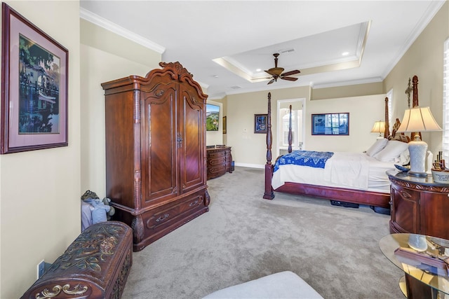 bedroom with crown molding, carpet flooring, ceiling fan, baseboards, and a tray ceiling