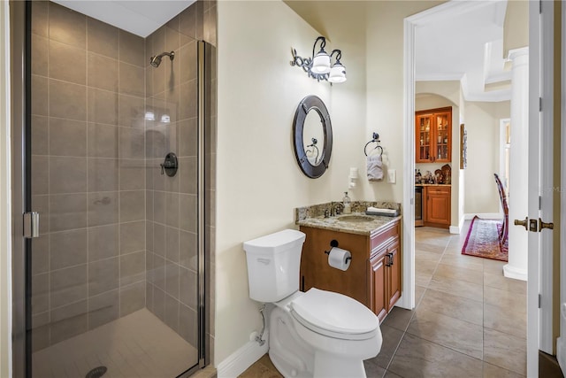 bathroom featuring vanity, toilet, baseboards, and a stall shower
