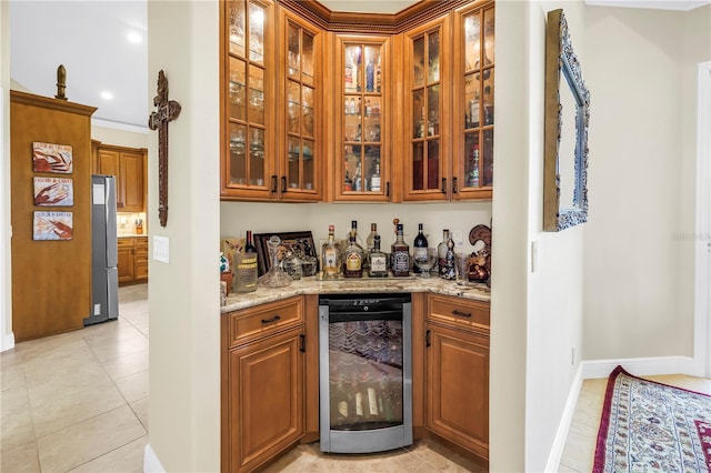 bar featuring baseboards, freestanding refrigerator, a bar, beverage cooler, and light tile patterned flooring