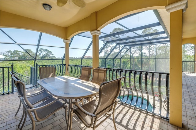 view of patio / terrace with glass enclosure, ceiling fan, outdoor dining space, and an outdoor pool