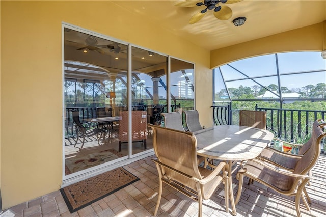 sunroom featuring ceiling fan and outdoor dining space