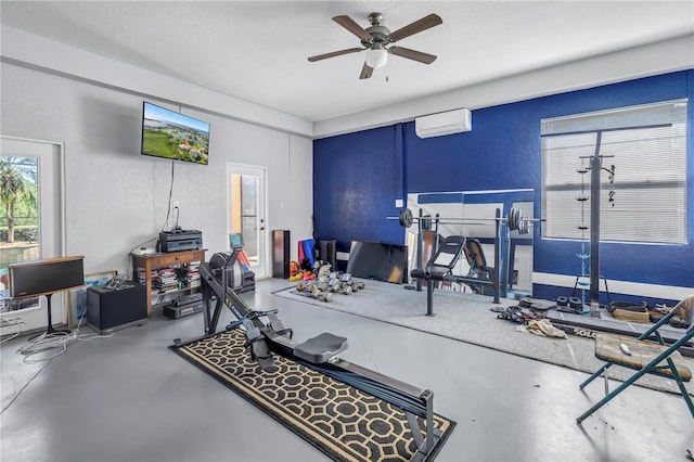 workout room featuring a ceiling fan, a textured wall, and a wall mounted AC