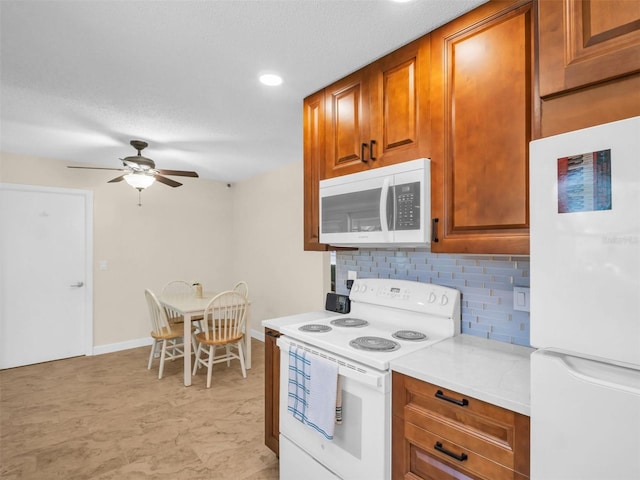 kitchen featuring a ceiling fan, white appliances, decorative backsplash, brown cabinets, and light countertops