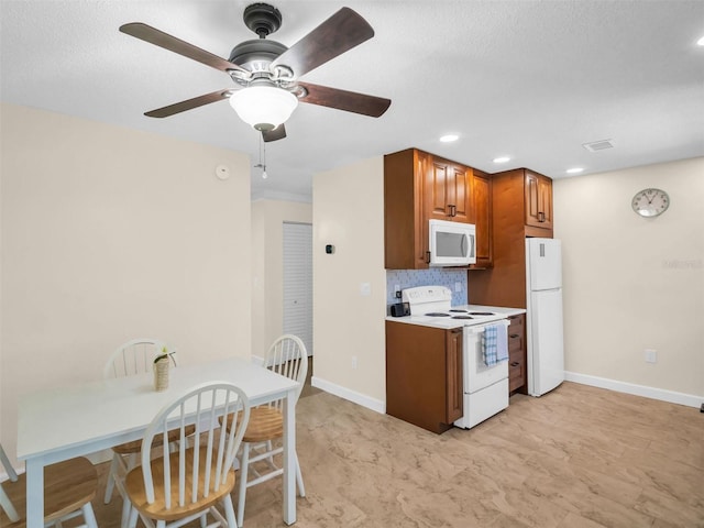 kitchen with brown cabinetry, white appliances, baseboards, and tasteful backsplash