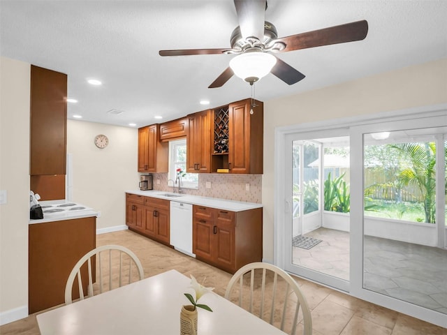 kitchen featuring decorative backsplash, light countertops, plenty of natural light, and dishwasher