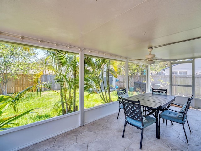 sunroom with a ceiling fan and outdoor dining space