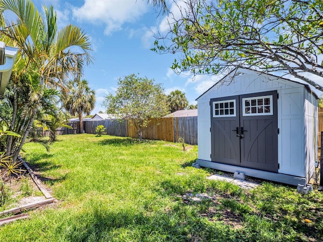 view of yard featuring an outbuilding, a shed, and a fenced backyard