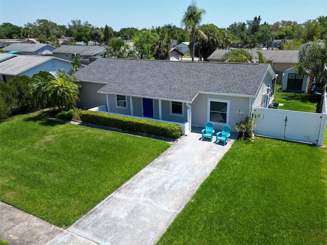 view of front of house featuring a front yard, roof with shingles, covered porch, and a gate