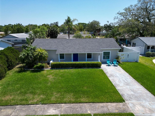 single story home with a gate, fence, a shingled roof, a front yard, and driveway
