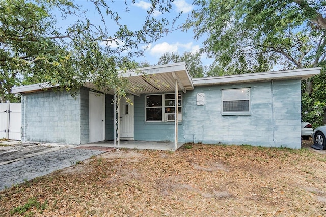 ranch-style house featuring concrete block siding and fence
