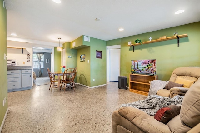 living area with baseboards, recessed lighting, visible vents, and light speckled floor