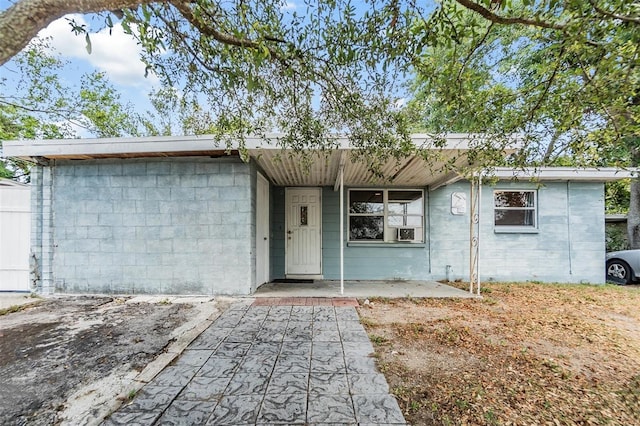 ranch-style home with concrete block siding and a porch