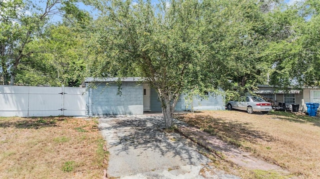 view of front of house with fence, a gate, and concrete block siding