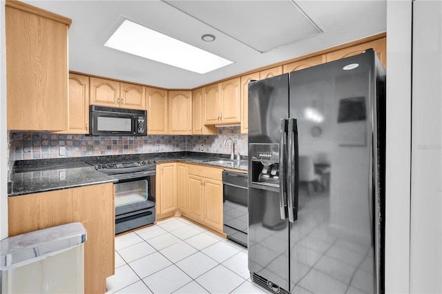 1 Key Capri Unit 303E, Treasure Island, FL 33706 - kitchen with black appliances, a sink, light brown cabinets, light tile patterned floors, and dark stone counters