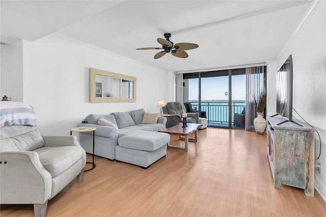 1 Key Capri Unit 303E, Treasure Island, FL 33706 - living room with light wood finished floors, ornamental molding, a ceiling fan, and a wall of windows