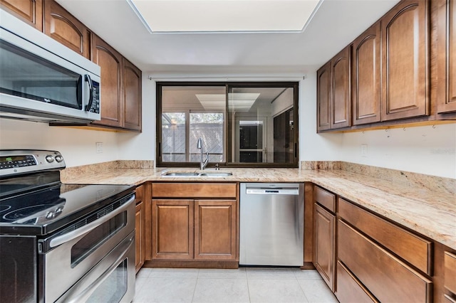 4002 Cypress Ct Unit 4002, Tampa, FL 33618 - kitchen with light tile patterned flooring, light stone countertops, a sink, brown cabinetry, and stainless steel appliances