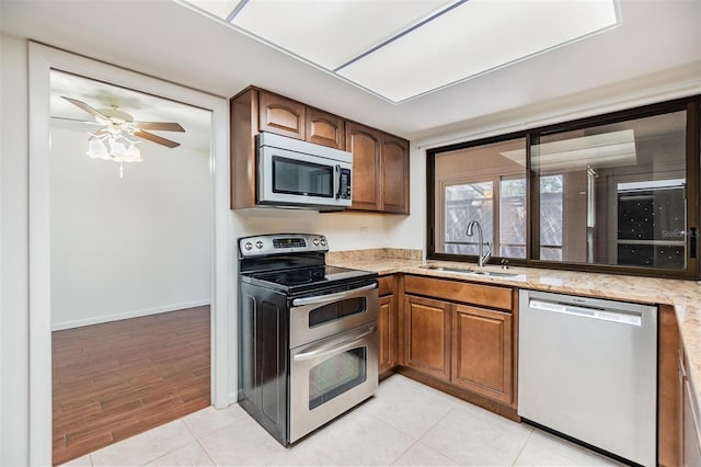 4002 Cypress Ct Unit 4002, Tampa, FL 33618 - kitchen featuring a sink, light stone countertops, stainless steel appliances, and brown cabinets