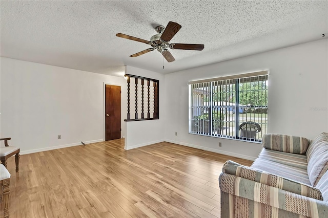 883 N Hollywood Cir, Crystal River, FL 34429 - living area with a ceiling fan, a textured ceiling, baseboards, and light wood-style floors
