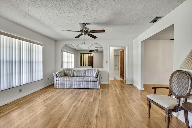 883 N Hollywood Cir, Crystal River, FL 34429 - living area featuring visible vents, baseboards, ceiling fan, a textured ceiling, and light wood-style flooring