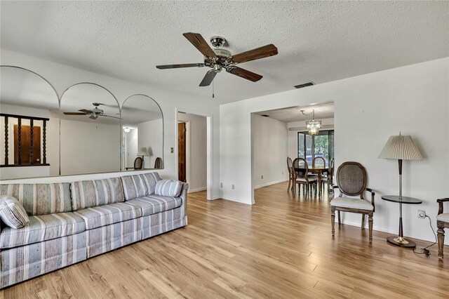 883 N Hollywood Cir, Crystal River, FL 34429 - living room featuring visible vents, a textured ceiling, ceiling fan with notable chandelier, and wood finished floors