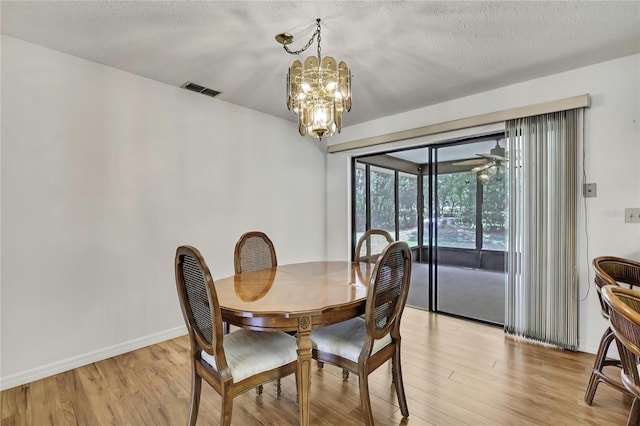 883 N Hollywood Cir, Crystal River, FL 34429 - dining area with baseboards, light wood finished floors, a textured ceiling, and a chandelier