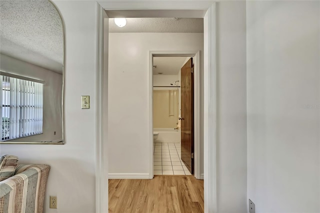 883 N Hollywood Cir, Crystal River, FL 34429 - corridor featuring baseboards, a textured ceiling, and wood finished floors
