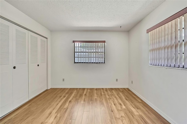 883 N Hollywood Cir, Crystal River, FL 34429 - unfurnished bedroom featuring a closet, baseboards, a textured ceiling, and wood finished floors