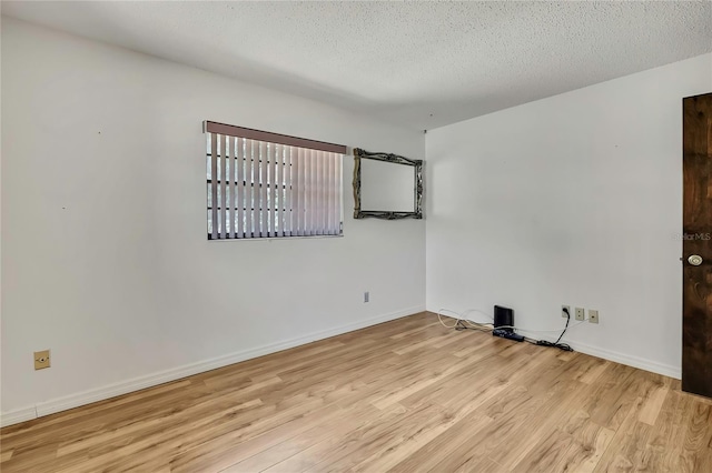 883 N Hollywood Cir, Crystal River, FL 34429 - spare room featuring baseboards, a textured ceiling, and wood finished floors