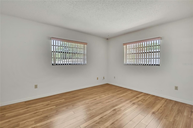 883 N Hollywood Cir, Crystal River, FL 34429 - spare room with light wood-style floors, a textured ceiling, baseboards, and a healthy amount of sunlight