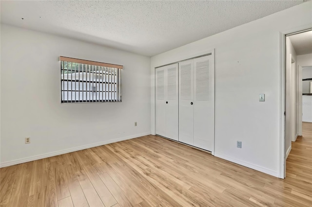 883 N Hollywood Cir, Crystal River, FL 34429 - unfurnished bedroom featuring baseboards, light wood-style flooring, a closet, and a textured ceiling
