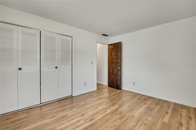 883 N Hollywood Cir, Crystal River, FL 34429 - unfurnished bedroom with baseboards, visible vents, light wood-style flooring, and a closet