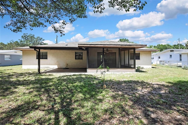 883 N Hollywood Cir, Crystal River, FL 34429 - back of house featuring stucco siding, a sunroom, a ceiling fan, a patio area, and a yard