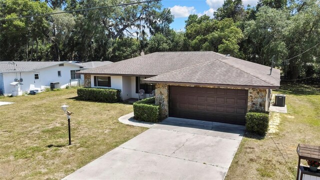 883 N Hollywood Cir, Crystal River, FL 34429 - ranch-style home with a garage, a front lawn, stone siding, roof with shingles, and driveway