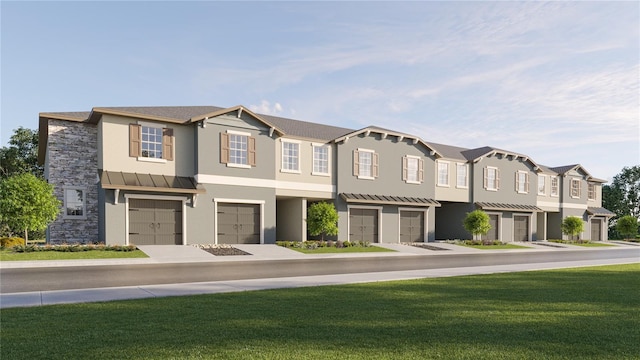view of property featuring a garage, a standing seam roof, a residential view, and stucco siding