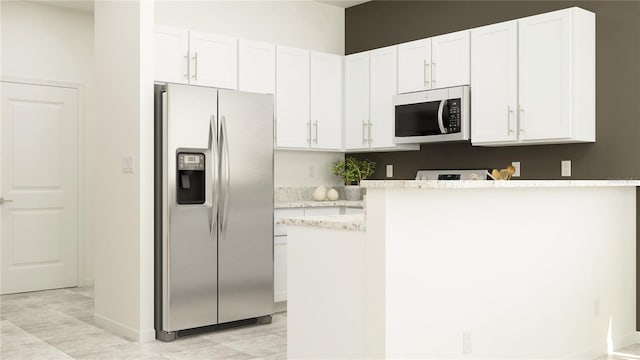 kitchen with stainless steel appliances, light stone countertops, white cabinetry, and a peninsula