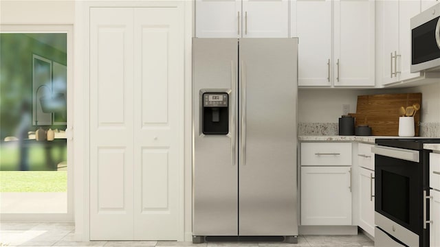 kitchen featuring white cabinetry, light stone countertops, appliances with stainless steel finishes, and light tile patterned floors