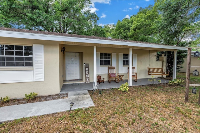 exterior space featuring stucco siding and covered porch