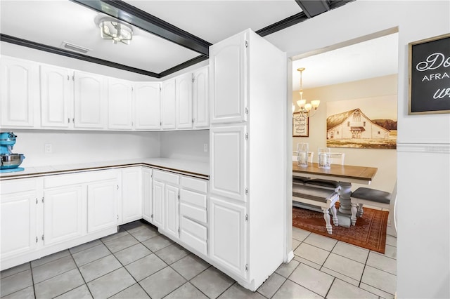 kitchen featuring visible vents, light tile patterned floors, light countertops, a notable chandelier, and white cabinetry
