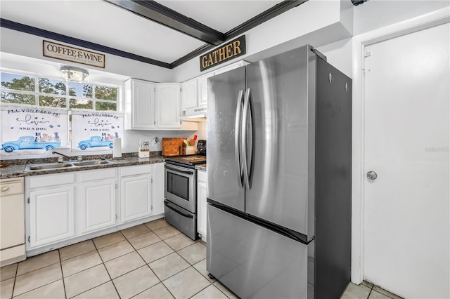 kitchen with dark countertops, a sink, white cabinets, under cabinet range hood, and stainless steel appliances