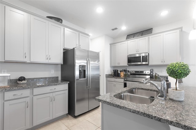 kitchen featuring a sink, dark stone countertops, stainless steel appliances, recessed lighting, and visible vents