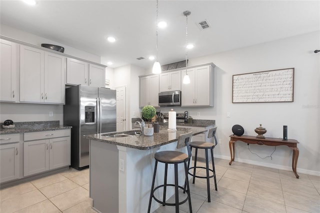 kitchen featuring visible vents, a sink, light tile patterned floors, and stainless steel appliances