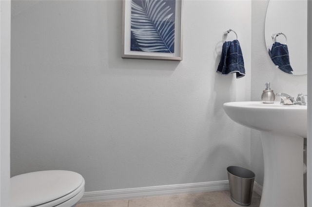 bathroom featuring a sink, baseboards, tile patterned floors, and toilet