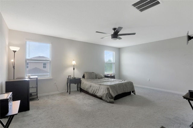 carpeted bedroom featuring visible vents, baseboards, and ceiling fan