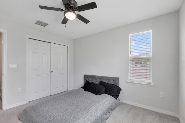 carpeted bedroom featuring a ceiling fan, baseboards, visible vents, and a closet