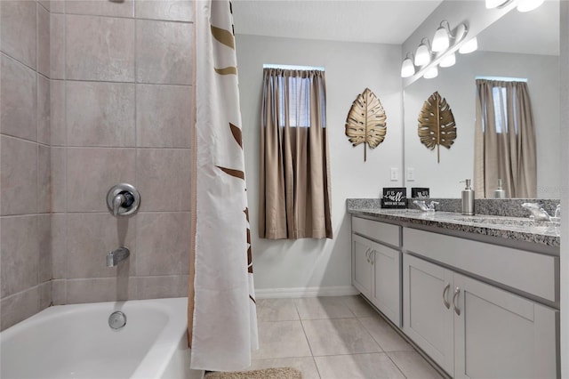 bathroom featuring double vanity, tile patterned floors, a sink, and a wealth of natural light