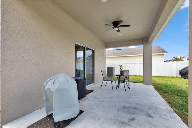 view of patio / terrace with a ceiling fan, fence, and a grill