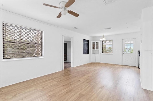 536 Braddock St S, Saint Petersburg, FL 33707 - unfurnished living room with visible vents, ceiling fan with notable chandelier, and light wood-style floors