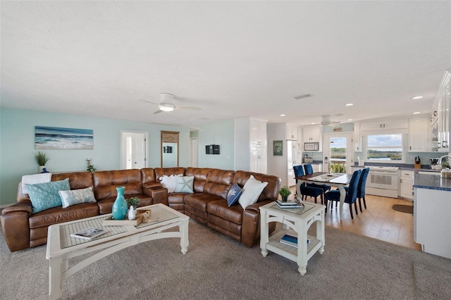living area with recessed lighting, ceiling fan, visible vents, and light wood finished floors