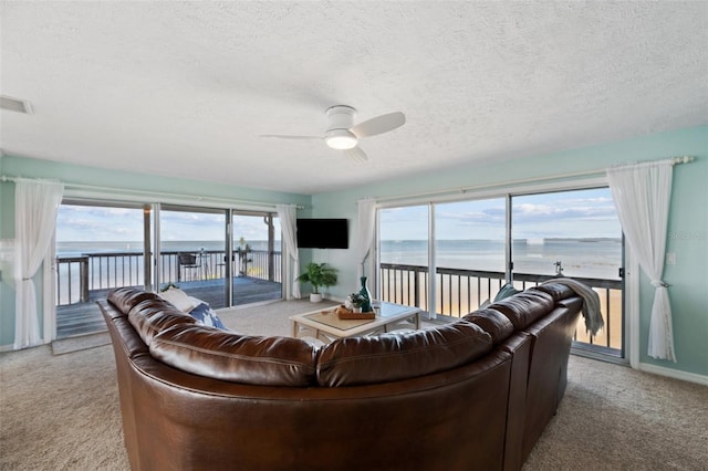 living room with visible vents, ceiling fan, a textured ceiling, and light colored carpet