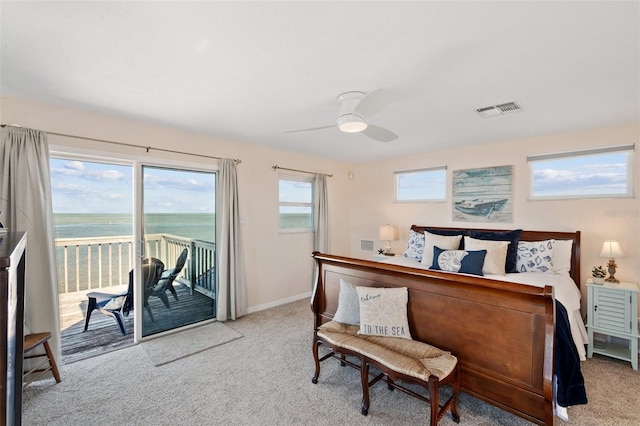 carpeted bedroom featuring a ceiling fan, access to exterior, visible vents, baseboards, and a water view